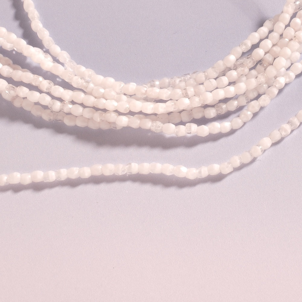 Petites perles facettées 3 mm blanc et transparent, éclat des facettes en gros plan