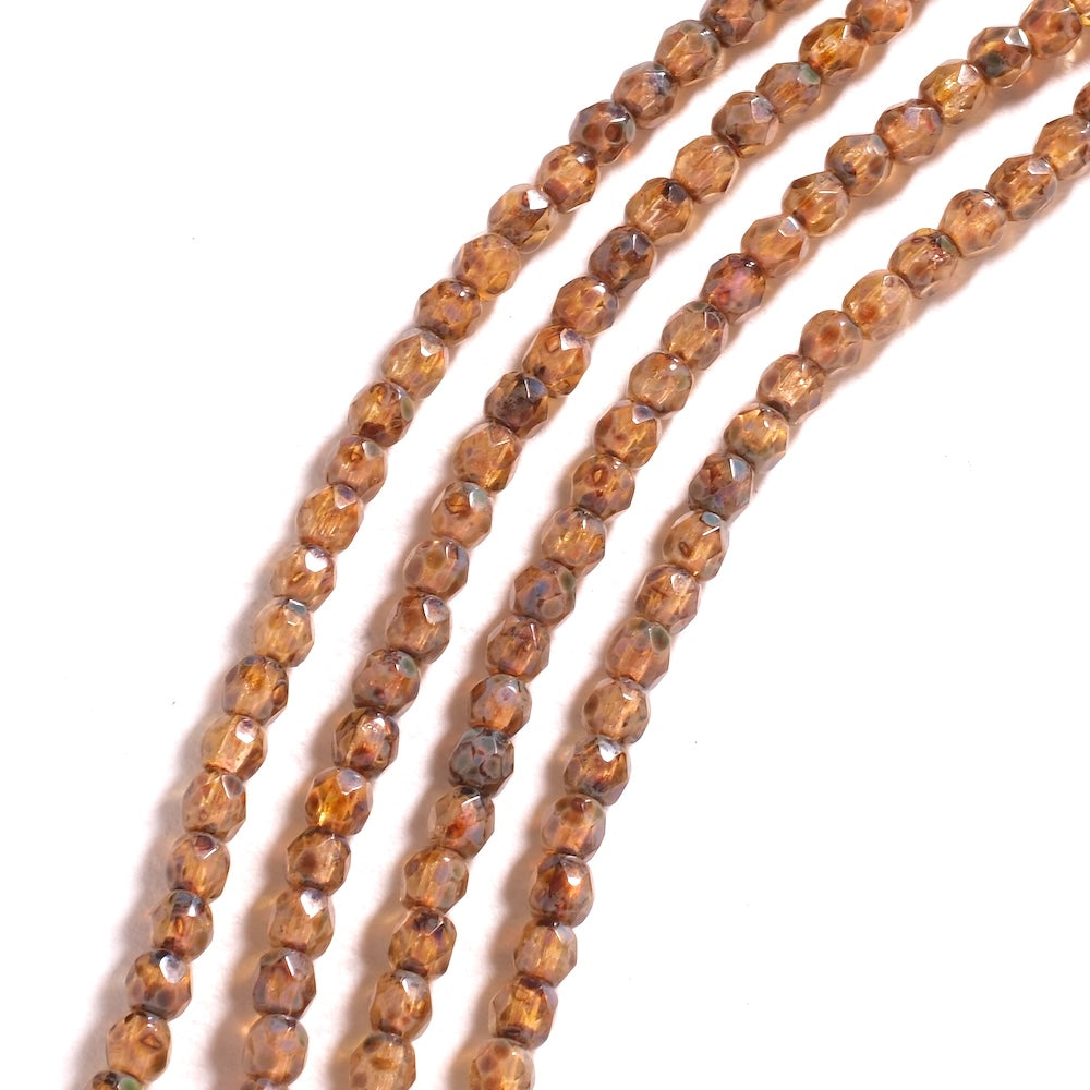 Quatre rangs de perles facettées 4 mm topaze, marbrures brunes et bronze de la finition Picasso
