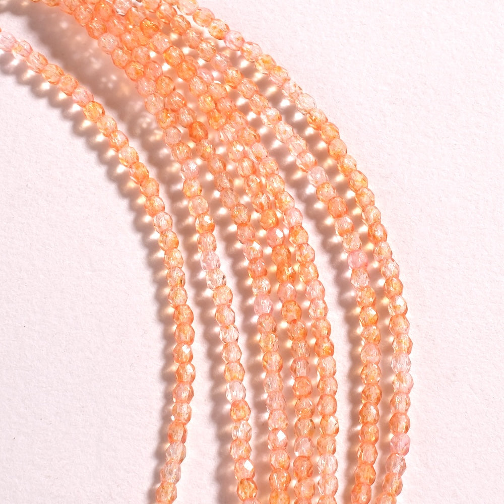 Fil de perles de Bohème rondes facettées 3 mm en verre orangé clair transparent