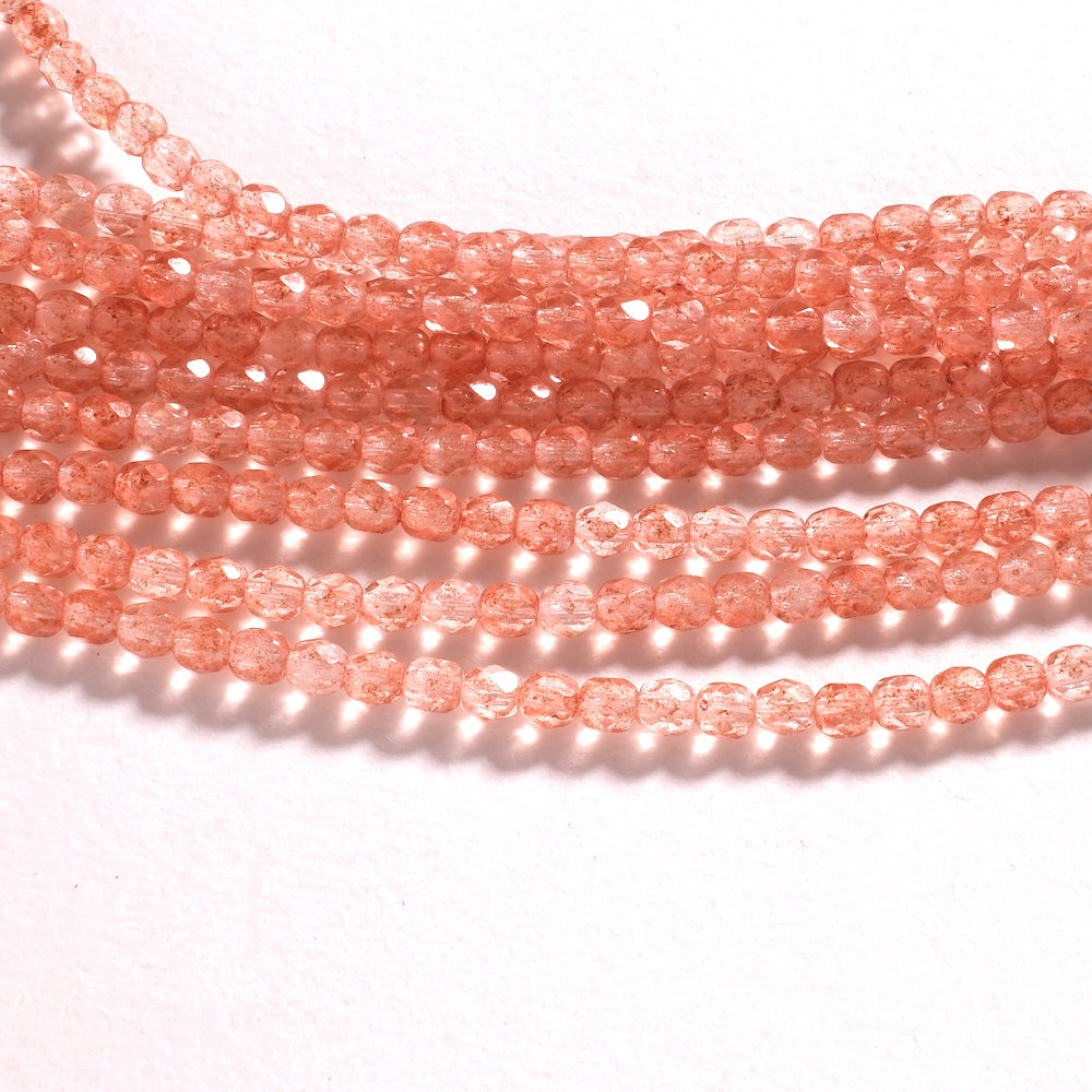 Rangs de perles facettées 4 mm rose translucide, inclusions cuivrées scintillantes