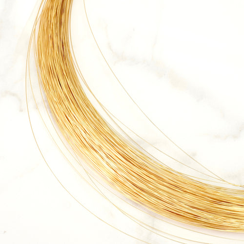 Fil de laiton souple 0,4mm doré à l'or fin 24K sur fond marbre.