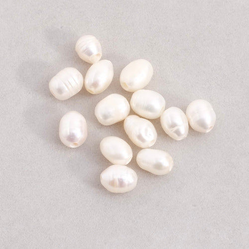 4 perles ovales allongées irrégulières de nacre naturelle.