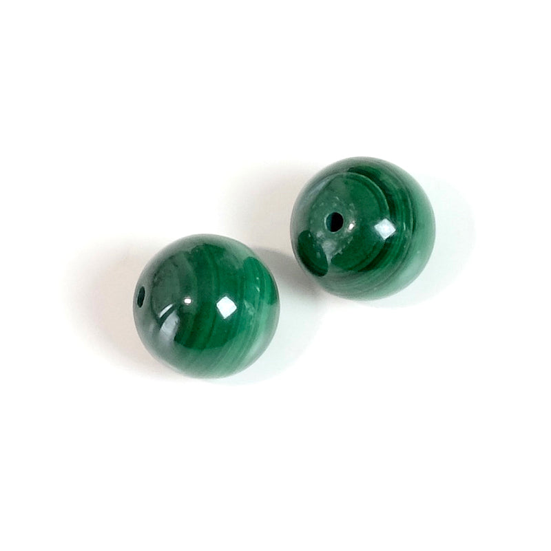 Deux perles rondes naturelles de malachite verte avec des motifs concentriques.