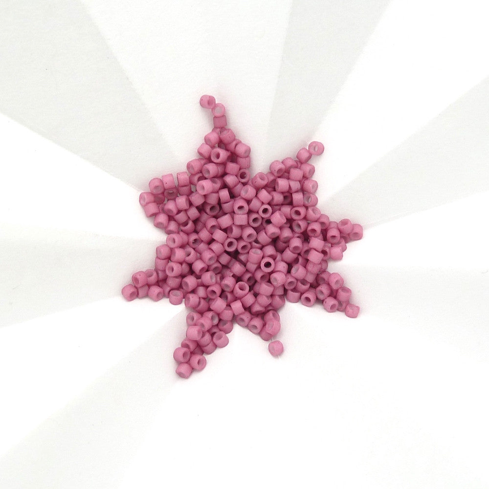 Perles Miyuki Délica 11/0 vieux rose mat opaque en forme d'étoile.