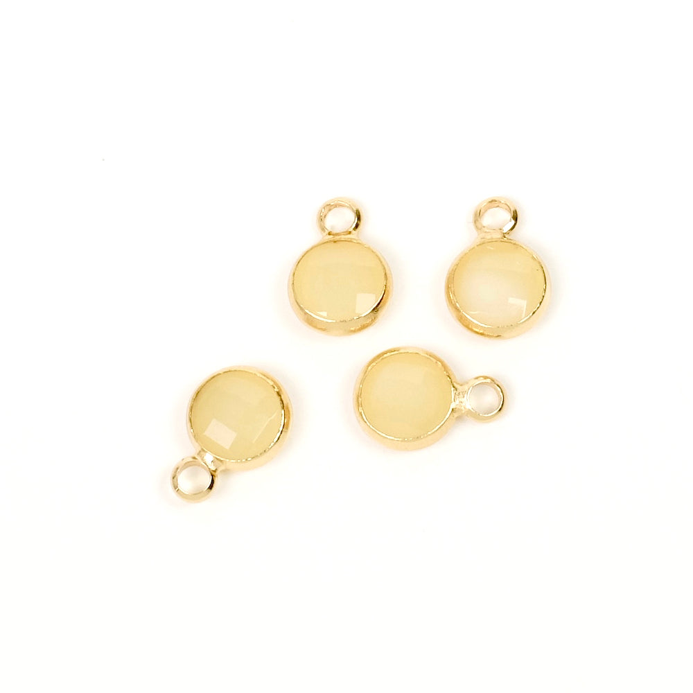 2 Opaque pastel yellow faceted glass and gold-plated metal pendants